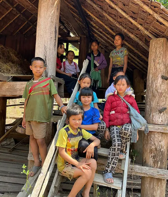 Children on the steps of a simple rural schoolhouse in northern Thailand